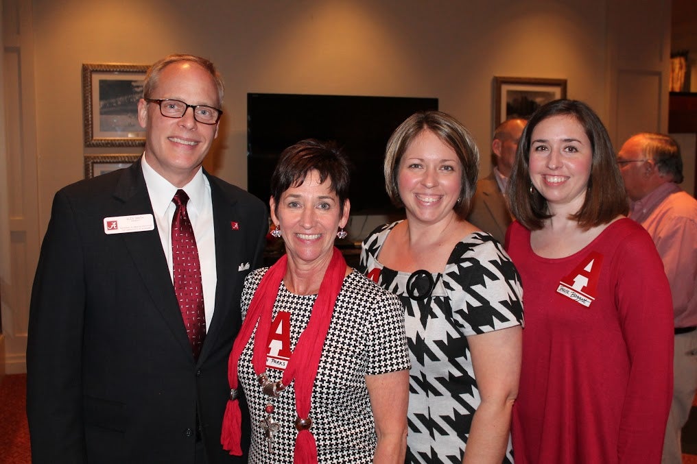 Group of people standing in room with dim light.