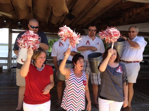 Group of people standing and holding red and white shakers.
