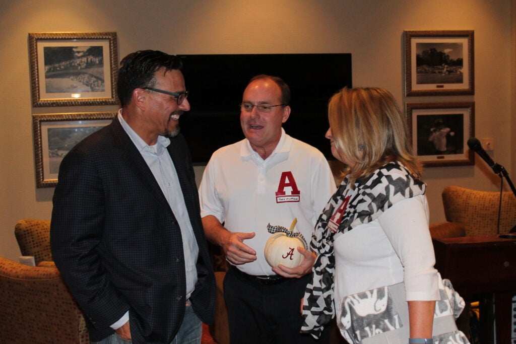 Group of people standing in room with dim light.