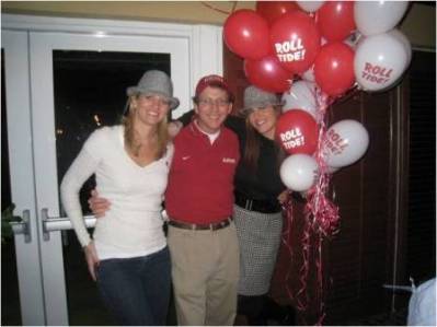 Group of people standing by red and white ballons.