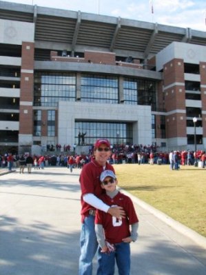 Two people standing outside in front of football stadium.