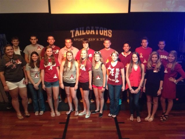 Group of people standing in room with dim light.