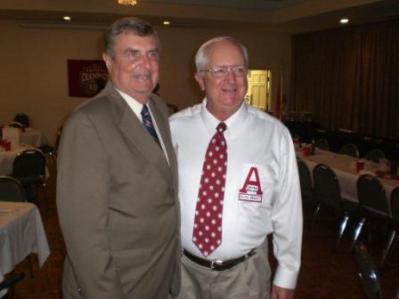 Two people standing in dim room.