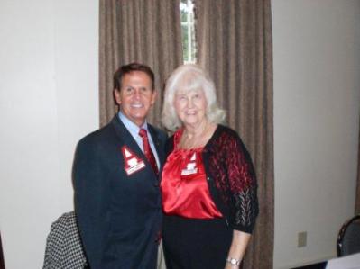 Two people standing in front of curtain.