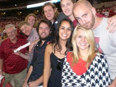 Group of people standing in football stadium.