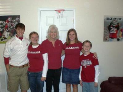 Group of people standing in front of white wall.