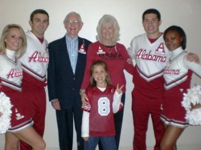 Group of people dressed in red and white standing in room.