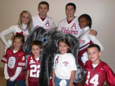 Group of people standing with Big AL in room.