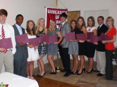 Group of people standing in room holding certificates.