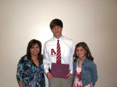 Group of people standing and one holding a certificate.
