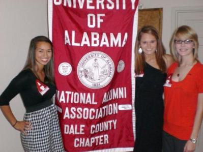 Group of people standing by red banner.