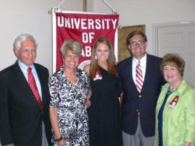 Group of people standing in front of red banner.