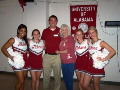 Group of people standing in front of red banner.