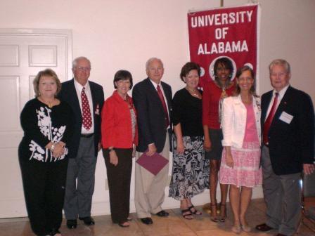 Group of people standing in front of white wall.