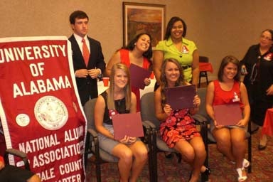 Group of people sitting and standing in front of beige wall.