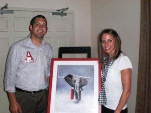 Two people holding picture of Elephant.
