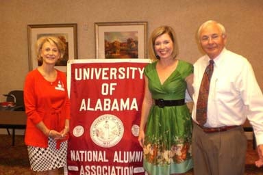 Group of people standing by red banner.