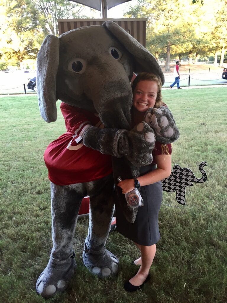 Girl hugging Big Al outside.