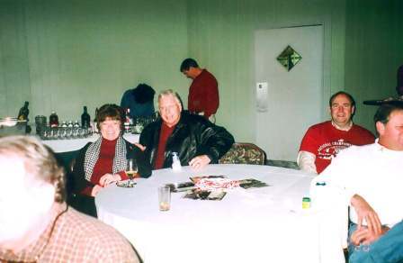 Two people siting at table with white table cloth.