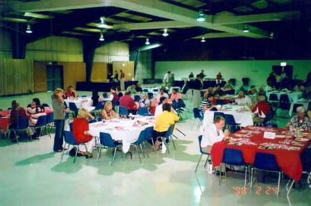 Group of people sitting in room with green background.