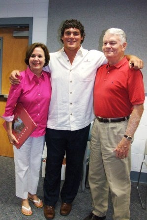 Group of people standing in room with white walls.