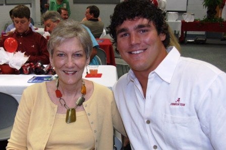 Lady in yellow sweater and man in white shirt sitting in room.