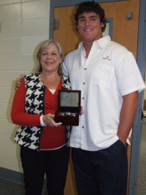 lady with black and white vest and red shirt holding a plaque and man white shirt.