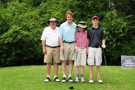 Group of men standing outside on golf course.
