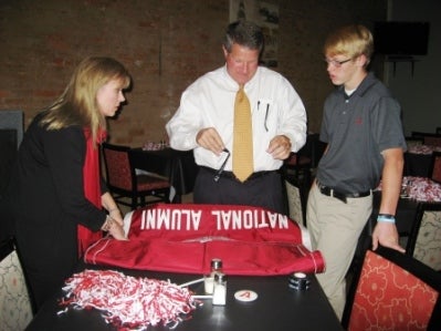 Group of people standing around table in dark room.