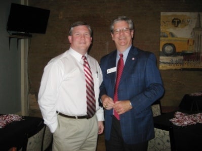 Man in white shirt, red tie and Calvin Brown.