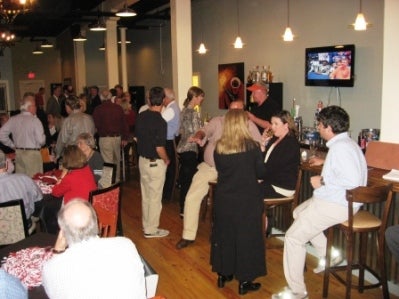 Group of people standing in a room with dim light.