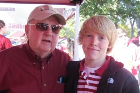 Two people standing outside dressed in red shirts.