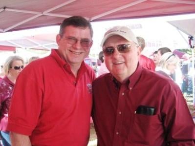 Two men in red shirts standing outside.