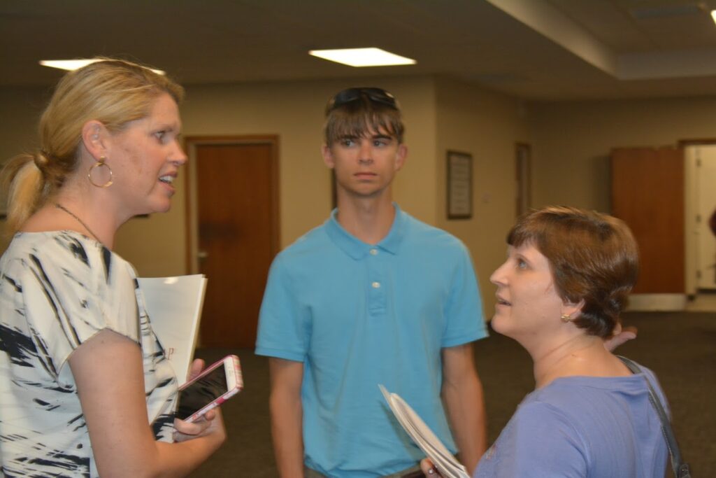 Group of people standing in room with dim light.