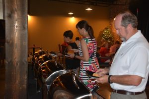 Group of people in buffet line with dim light.