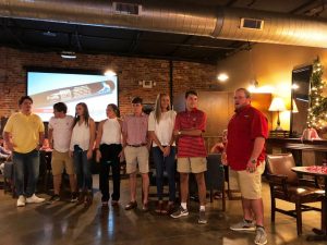 Group of people standing in room with dim light.