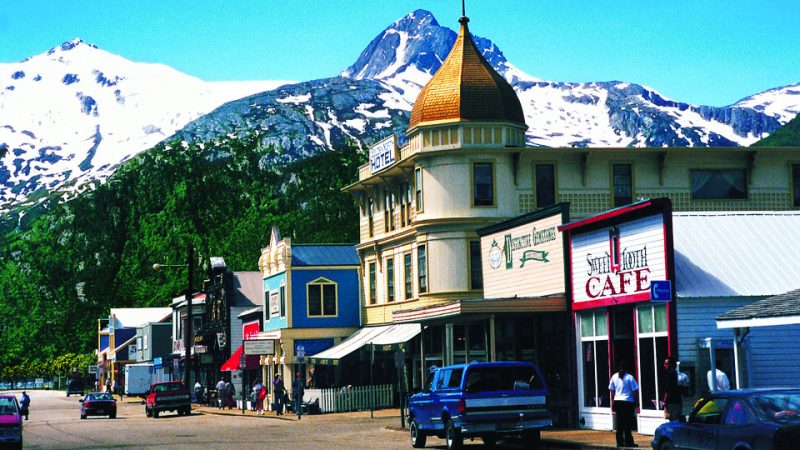 A small town main street in Alaska with mountains in the background