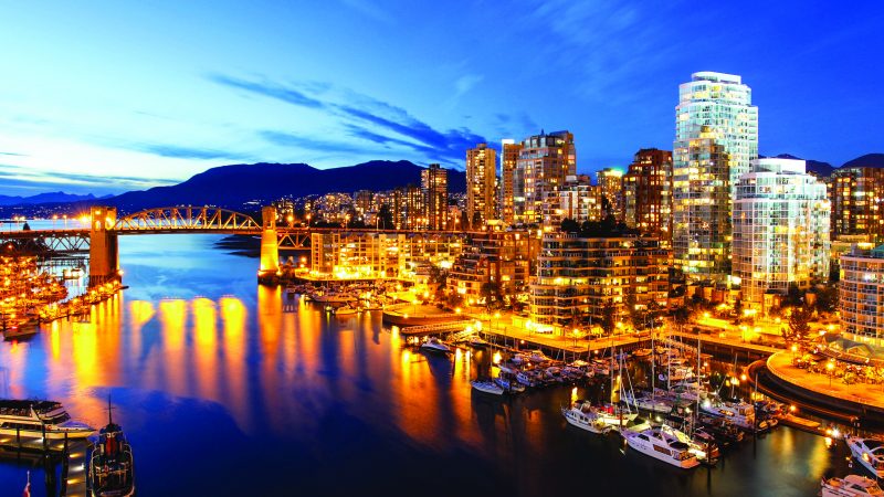 An aerial view of some docks and high rises in the city of Vancouver a little past sundown