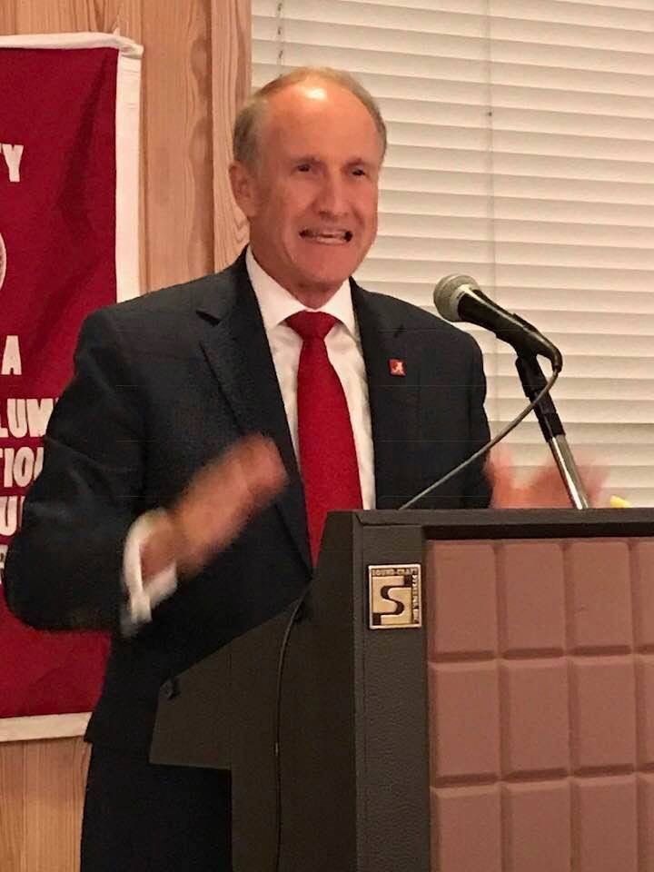 Dr. Stewart Bell standing behind podium