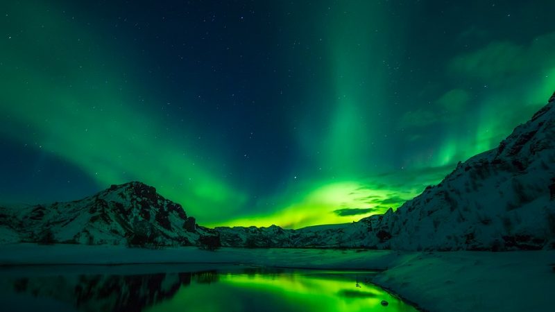 a picture of the northern lights with mountains in front