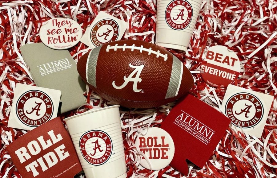 UA-themed buttons, cups, stickers and cheer shakers surrounding a football
