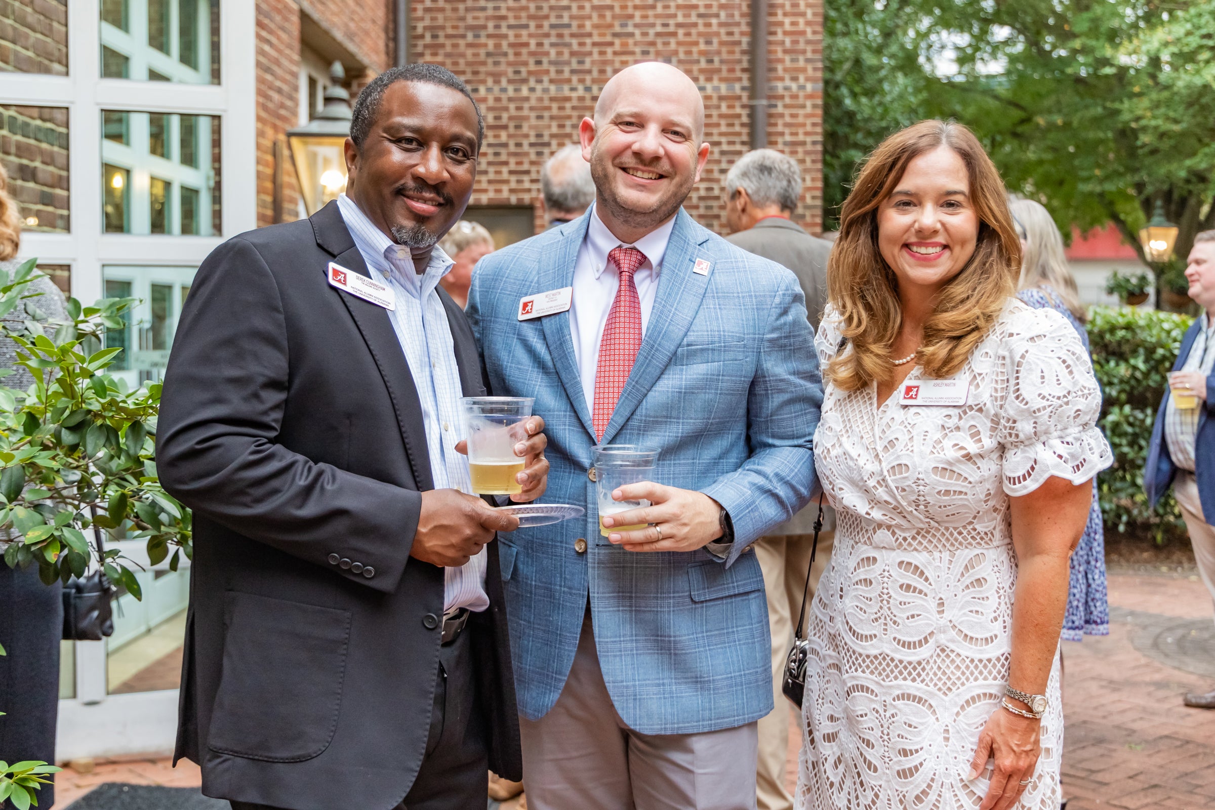 Three UA alumni standing together in front of Alumni Hall